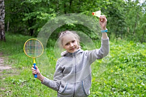 Little girl playing badminton on the street photo