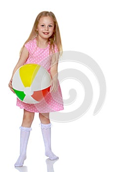 Little girl is playing with a ball