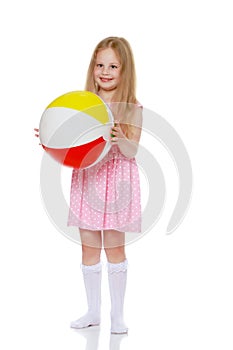 Little girl is playing with a ball