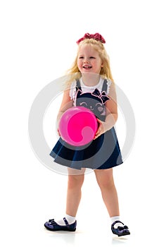 Little girl is playing with a ball