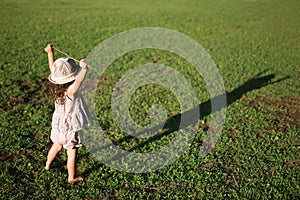 Little girl playing barefoot in the meadow