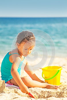 Little girl is playing on the beach