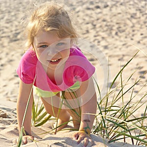 Little girl playing in the beach sand