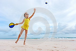 Little girl playing beach tennis