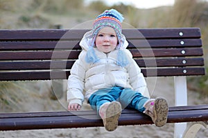 Little girl playing on the beach at winter