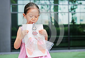 Little girl playing blowing with Simulate breathing of the lungs. Healthcare concept