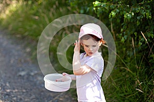 little girl playing with a bucket of water in the park on a sunny day