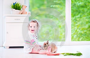 Little girl playing with a bunny