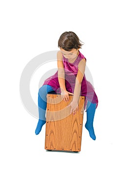 Little girl playing with a cajon isolated on white