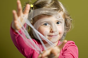 Little girl playing cats cradle game