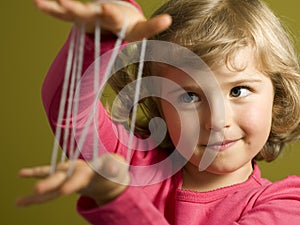 Little girl playing cats cradle game