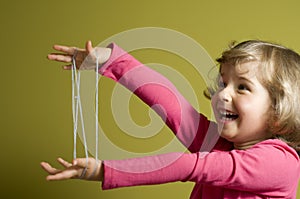 Little girl playing cats cradle game