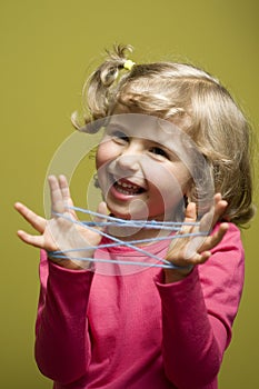 Little girl playing cats cradle game