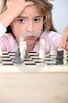 Little girl playing chess