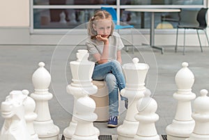 Little girl playing chess game.