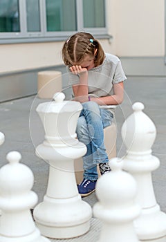 Little girl playing chess game.