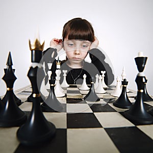 Little girl playing chess on white