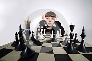 Little girl playing chess on white