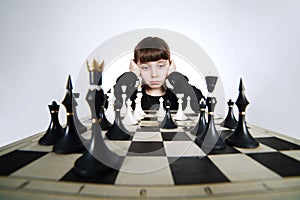 Little girl playing chess on white