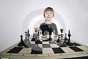 Little girl playing chess on white