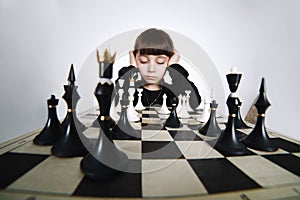 Little girl playing chess on white