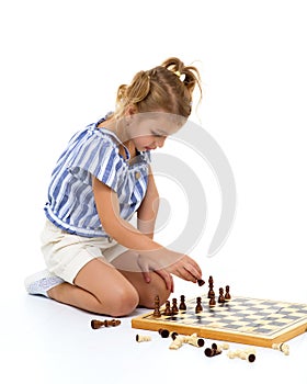 Little girl playing chess.On white background.