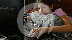 Little girl playing child in the notebook online game laptop