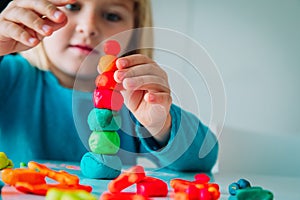 Little girl playing with clay molding shapes, kids crafts