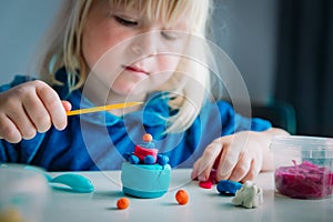 Little girl playing with clay molding shapes, kids crafts