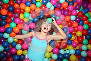 Little girl playing in colorful balls playground