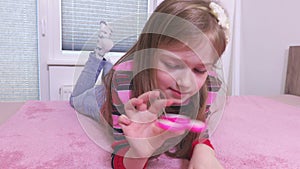 Little girl playing with colorful fidget spinner