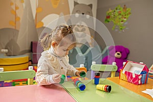 Little Girl Playing with Colorful Stacking Cups