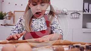 Little girl playing with cookie dough rolling it with her hands