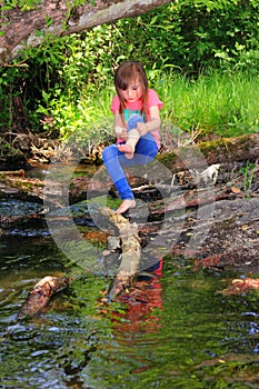 Little girl playing in a creek