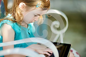 Little girl playing on a digital tablet