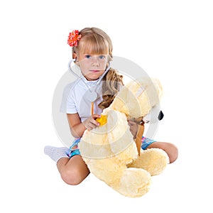 Little girl playing doctor with toy bear