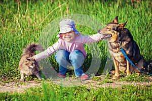 Little girl playing with dog and cat