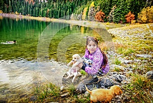 Little girl playing with dogs on th coast of the Black Lake ( Cr