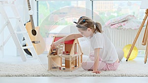 Little girl playing with doll house