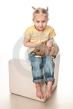 Little girl playing with Easter bunny on a white background