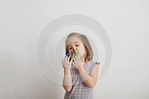 Little girl playing with felt tip pens stuff. baby girl painting and playing. colorful felt pen caps on fingers