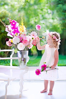 Little girl playing with fresh flowers