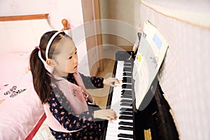 Little girl playing the piano at home