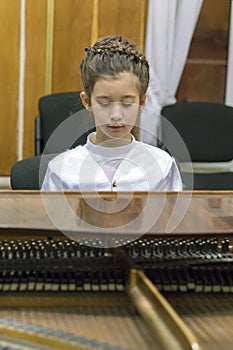 little girl playing the grand piano. vertical photo photo