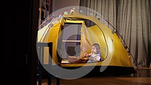 little girl playing guitar in her hut home, tent, girl learns to play guitar