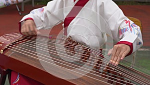 A little girl is playing Guzheng, a traditional Chinese musical instrument