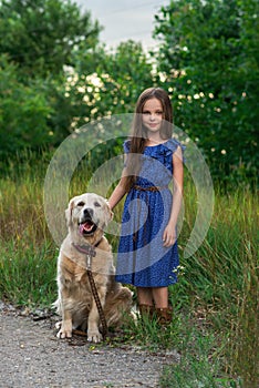 Little girl playing with her big dog outdoors in rural areas in summer