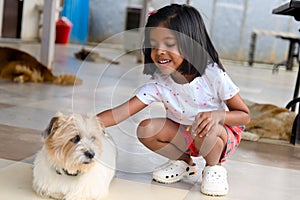 Little girl playing with her dog at backyard Selective focus