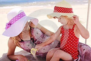 Little girl playing with her mother on the shore of the sea