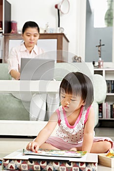 Little girl playing while her mother working